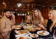 Group of friends enjoying a midday buffet on an Abu Dhabi dhow lunch cruise with skyline views