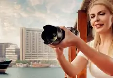 Traveller photographing the Yas Island waterfront from a daytime Abu Dhabi sightseeing dhow cruise