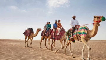 Family camel trekking experience included in Abu Dhabi holiday packages