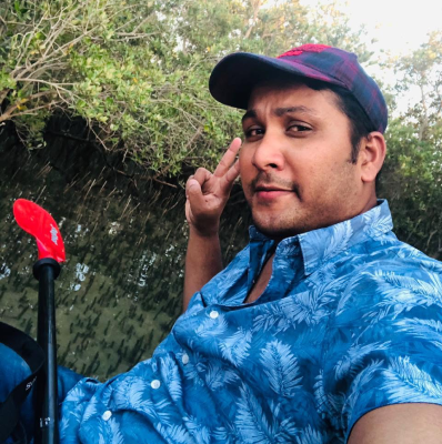 Seyed Shifaam kayaking through the Eastern Mangroves in Abu Dhabi with a paddle beside him