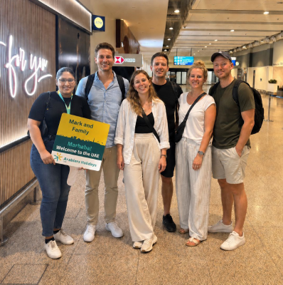 Piumi Samarasinghe meeting Arabiers guests at Dubai International Airport arrivals with a Marhaba welcome board