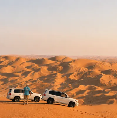 Mujeeb Rahman with Arabiers 4x4 vehicles overlooking the vast Liwa Empty Quarter dunes during a guided desert route inspection