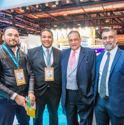 Seyed Shifaam wearing an exhibitor badge with industry partners at World Travel Market, ExCeL London