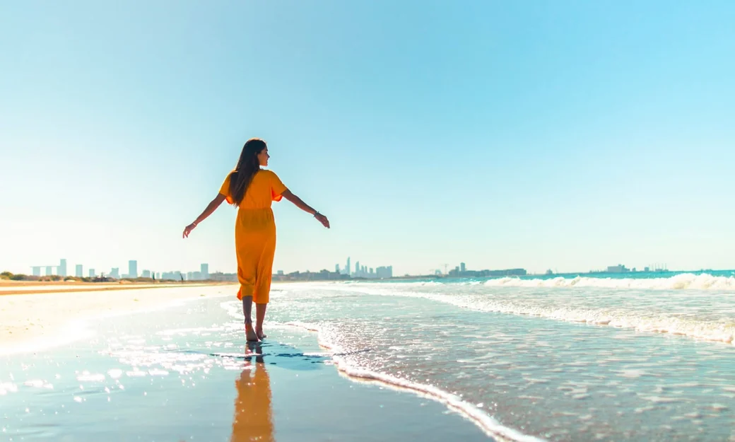 Visitor walking along Abu Dhabi Corniche beach