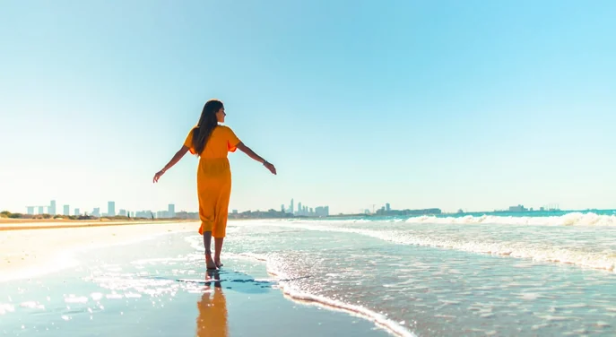 Visitor walking along Abu Dhabi Corniche beach