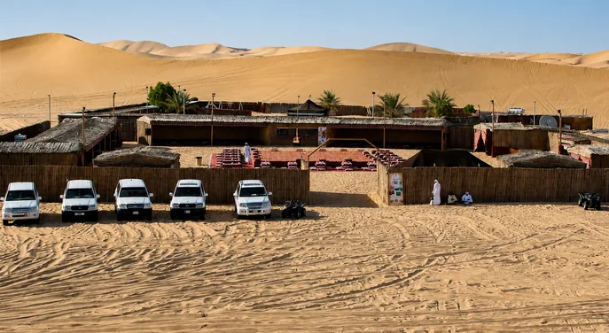 Traditional Abu Dhabi evening desert safari camp surrounded by dunes