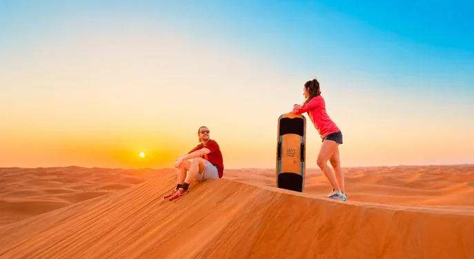 Guests sandboarding during a morning buggy tour in Al Khatim