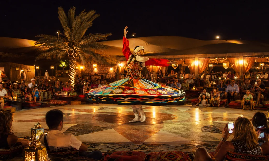 Live tanoura show watched by guests at an Abu Dhabi desert camp