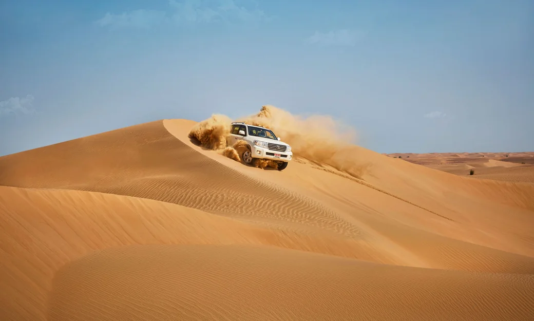 SUV descending a dune during an Abu Dhabi desert safari