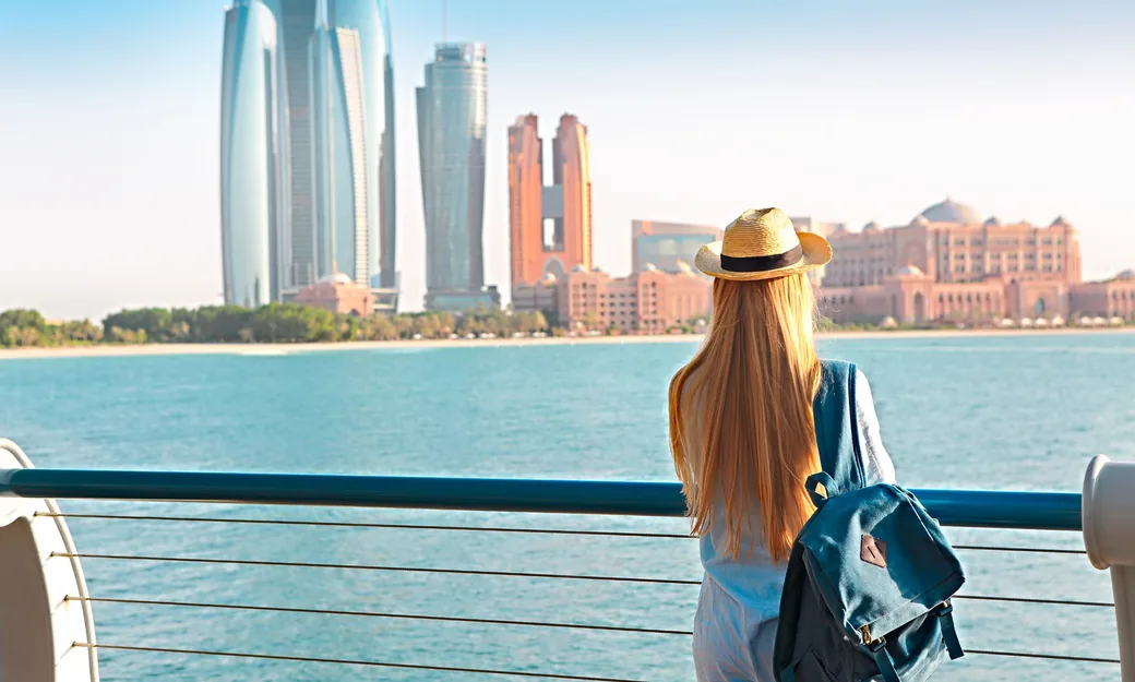 Traveller looking toward Emirates Palace from the Abu Dhabi Corniche