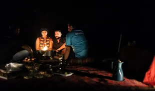 Guests gathered for an outdoor BBQ dinner at the Liwa overnight desert camp