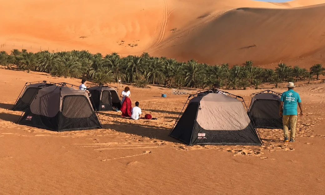 Overnight camping tents set beside the Liwa Oasis and towering Empty Quarter dunes