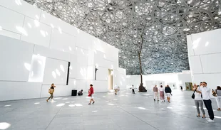 Visitors beneath the Louvre Abu Dhabi dome