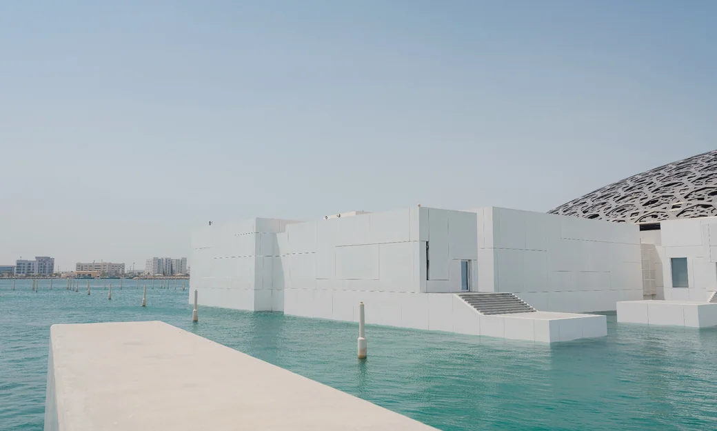 Louvre Abu Dhabi white galleries surrounded by turquoise water
