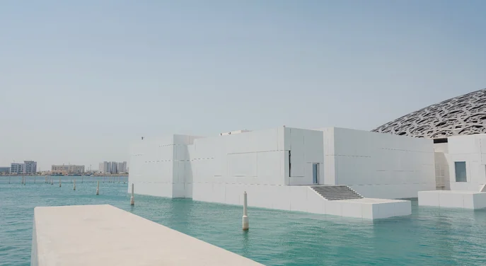 Louvre Abu Dhabi white galleries surrounded by turquoise water