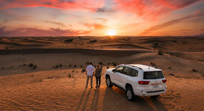 Private Toyota Land Cruiser stopped among the dunes at sunset