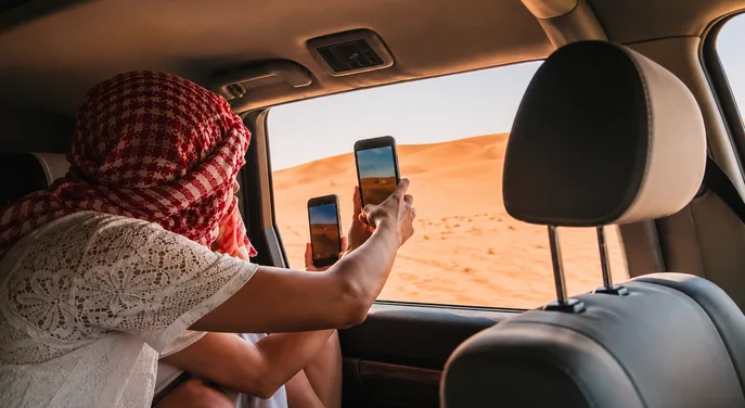 Guest photographing the dunes from a private Land Cruiser