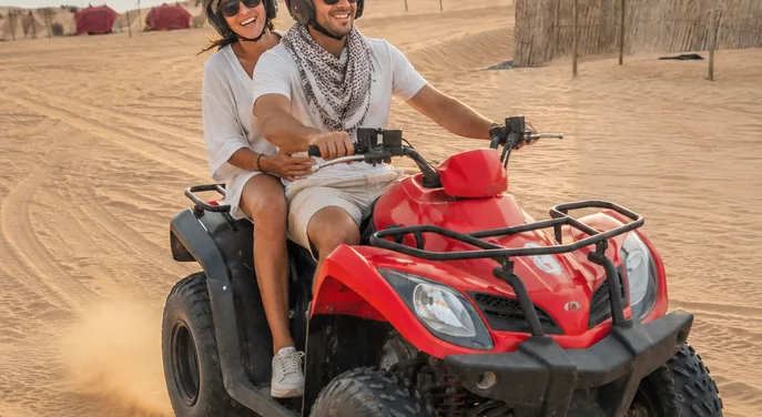 Guests riding a quad bike during a premium Abu Dhabi desert safari