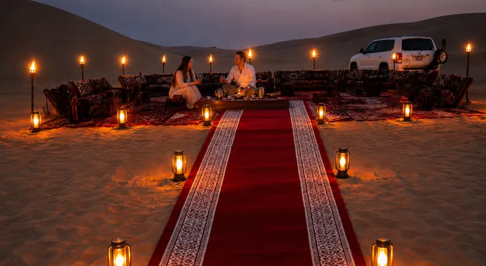Couple seated at a private Royal Red Carpet Majlis in the Abu Dhabi desert