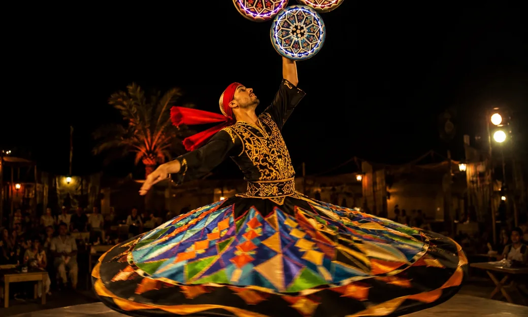 Tanoura dancer performing during an evening desert safari show in Abu Dhabi