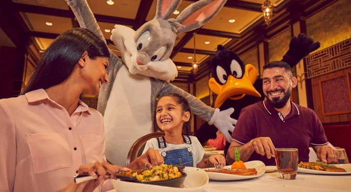 Family dining with Bugs Bunny and Daffy Duck at Warner Bros World Abu Dhabi