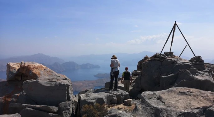 Trekkers standing among large rocks near the Jebel Sham summit viewpoint