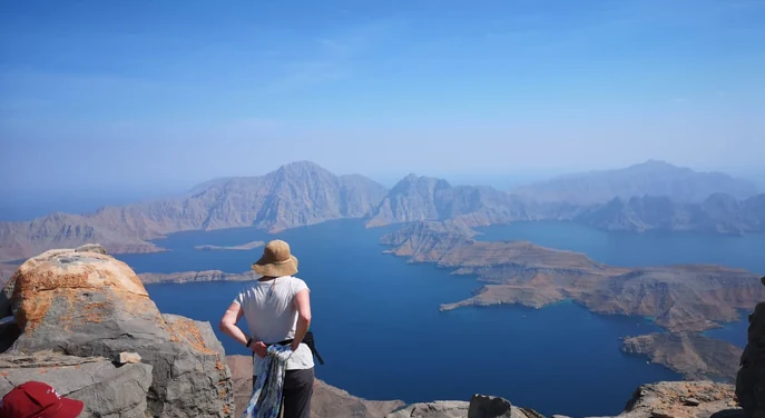 Traveller overlooking the dramatic fjords from the Jebel Sham summit area