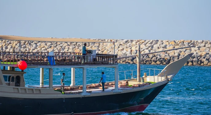 Open-deck traditional dhow cruising on the waters near Khasab