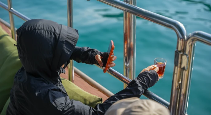 Traveller enjoying tea on a traditional dhow during the Khasab fjord cruise