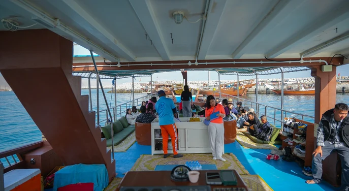 Guests relaxing aboard a traditional dhow at Khasab harbour before the full day cruise