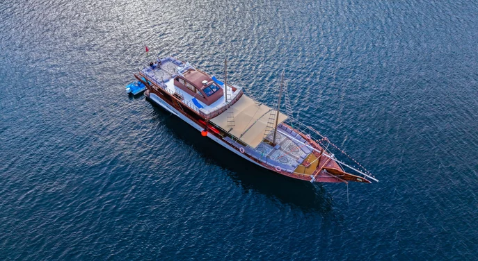 Aerial view of a traditional dhow cruising on the blue waters of Khasab