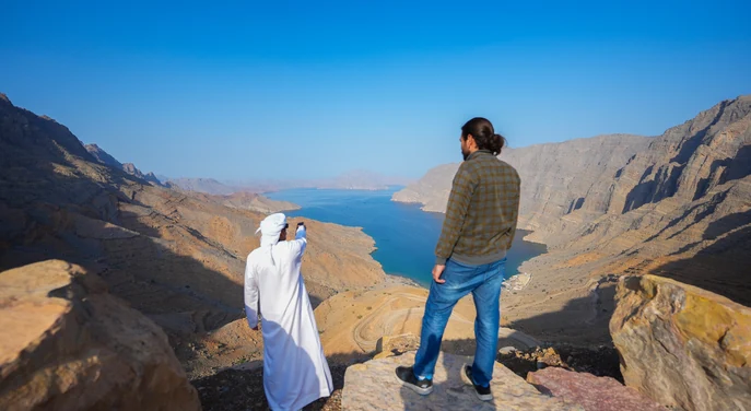 Local guide and traveller overlooking the Khor Najid fjord from the mountains of Musandam