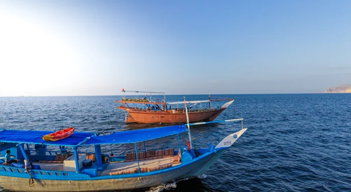 Traditional dhows cruising across the open sea near Khasab