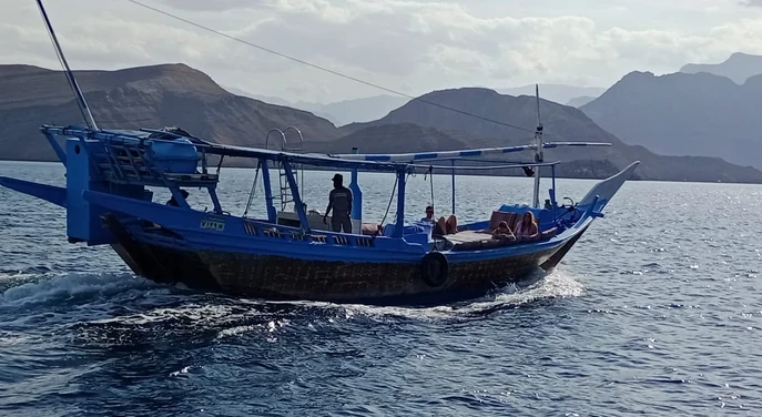 Guests relaxing on a traditional dhow during a Musandam fjord cruise