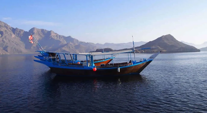 Traditional dhow boat cruising through the Musandam fjords