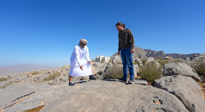 Local guide showing a traveller the rocky landscape near Jebel Harim in Musandam