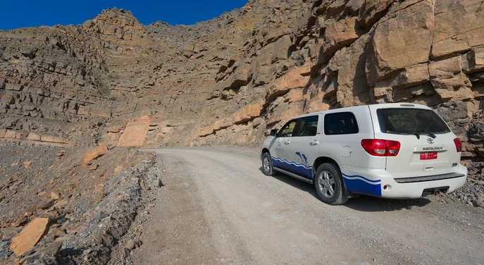 4WD vehicle driving along a rugged mountain road during a Musandam safari