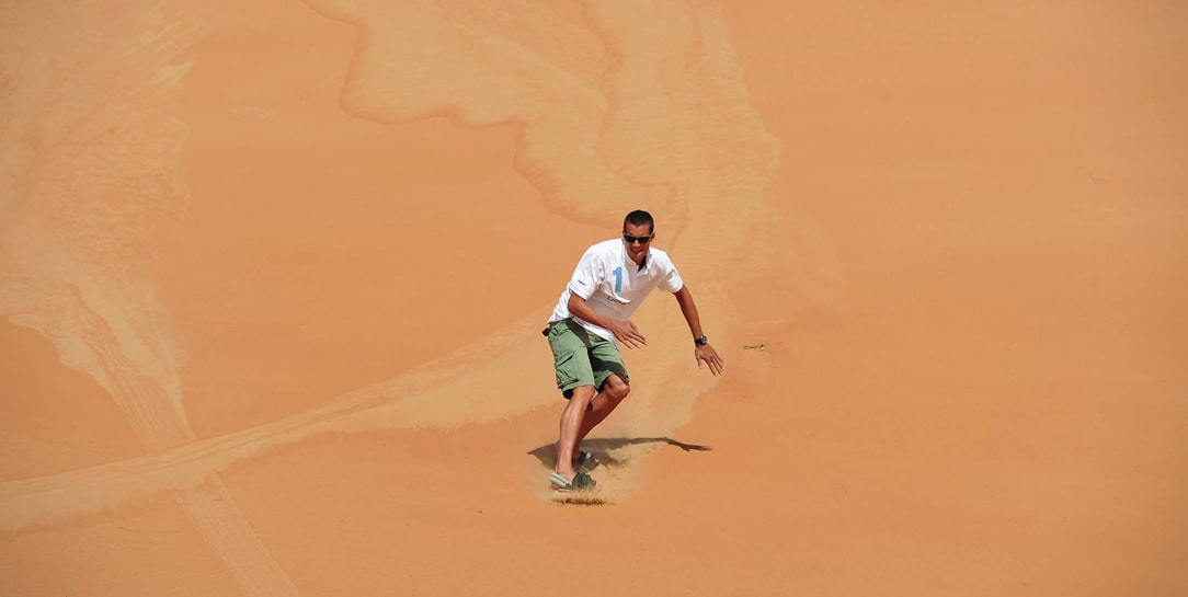Sandboarding experience on a dune in the Abu Dhabi desert