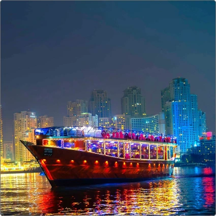 Illuminated traditional dhow boat at night on a Dubai Creek dinner cruise