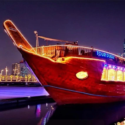 Traditional dhow lit up at night on a Dubai Marina dinner cruise