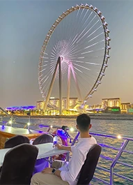 Couple dining on the deck with Ain Dubai view on a Marina cruise