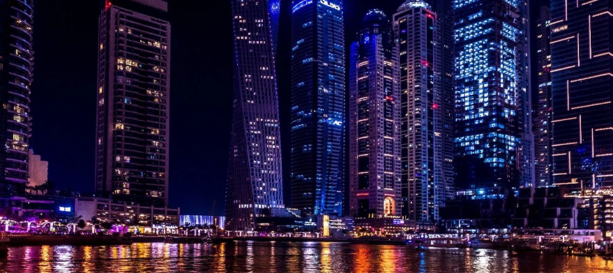 Dubai Marina skyscrapers lit up at night seen from the water
