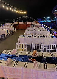Upper deck seating on a Dubai Creek dhow lit with festive lights