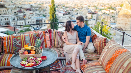 A UAE couple relaxing on a hotel terrace abroad at golden hour