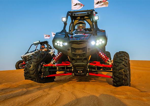 Dune buggy with riders during an evening desert tour in Dubai