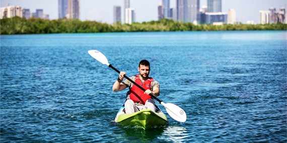Guided kayak tour gliding past mangrove trees at Eastern Mangrove Lagoon National Park, Abu Dhabi