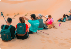 Travellers on a Liwa day tour resting on the dune crest