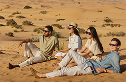 Group enjoying an evening desert tour in Ras Al Khaimah with a 4x4 vehicle