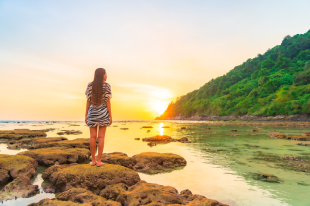 Solo traveller standing by the ocean during sunset in Sri Lanka